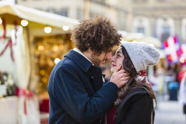 Verliebtes junges Paar küsst sich auf dem Weihnachtsmarkt - MGIF00311