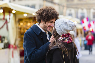 Happy affectionate young couple at Christmas market - MGIF00312