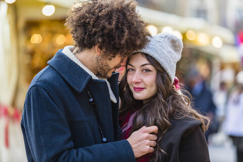 Happy affectionate young couple at Christmas market stock photo