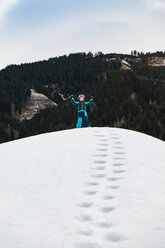 Italy, Trentino-Alto Adige, happy boy standing on a hill in winter - MGIF00322