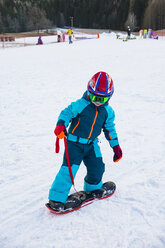 Italien, Trentino-Südtirol, Junge fährt auf kleinem Snowboard auf der Piste - MGIF00327