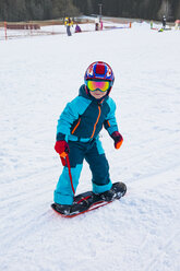Italien, Trentino-Südtirol, Junge fährt auf kleinem Snowboard auf der Piste - MGIF00328