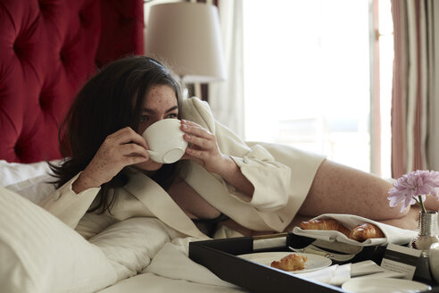 Teenage girl having breakfast in bed - AMEF00016