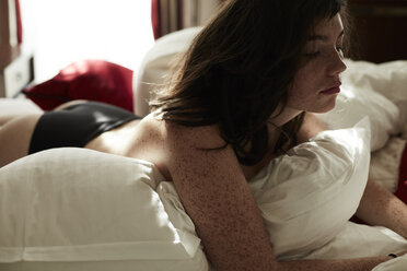 Semi-dressed teenage girl lying in bed - AMEF00021