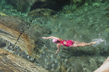 Schweiz, Tessin, Verzascatal, Frau schwimmt im erfrischenden Fluss Verszasca - GWF05955