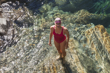 Schweiz, Tessin, Verzascatal, Porträt einer glücklichen Frau im Badeanzug, die im Fluss Verszasca steht - GWF05956