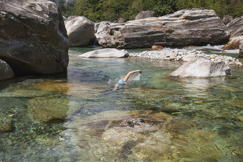 Schweiz, Tessin, Verzascatal, Frau schwimmt im erfrischenden Fluss Verszasca, lizenzfreies Stockfoto