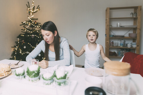 Frau mit kleinem Sohn in der Küche zur Weihnachtszeit, lizenzfreies Stockfoto