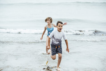 Playful siblings running in sea - CAVF62395