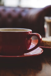 Nahaufnahme einer roten Kaffeetasse auf dem Tisch eines Cafés - CAVF62403