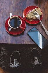 Low section of man by table with breakfast and smart phone at cafe - CAVF62404