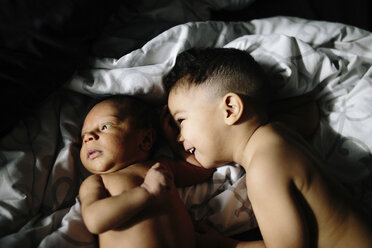 Hoher Winkel Blick auf glückliche shirtless Baby Junge Blick auf Bruder, während auf dem Bett liegend - CAVF62509