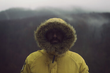 Close-up portrait of man wearing yellow fur coat standing outdoors during winter - CAVF62535