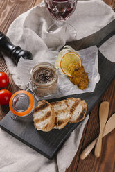 High angle view of fresh meat paste with toasted breads served on black cutting board - CAVF62546