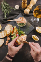 Cropped hand of man spreading liver paste on sliced bread - CAVF62551