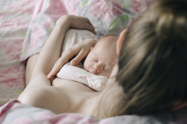 Hohe Winkel Ansicht der oben ohne Mutter hält niedlichen schlafenden Tochter beim Sitzen auf dem Bett zu Hause - CAVF62588