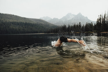 Hemdloser Mann taucht im See gegen den klaren Himmel im Wald - CAVF62620