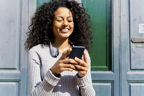 Laughing woman holding smartphone stock photo