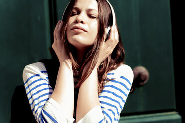 Junge Frau hört Musik mit geschlossenen Augen - FMOF00443