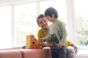 Vater und Sohn spielen mit einer Spielzeugkasse - JOSF03084