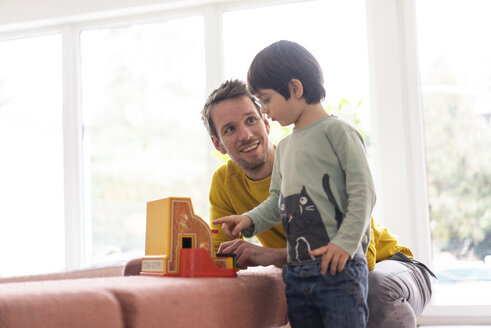 Vater und Sohn spielen mit einer Spielzeugkasse - JOSF03084