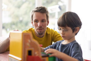 Vater und Sohn spielen mit einer Spielzeugkasse - JOSF03086