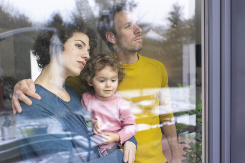 Happy family looking out of window, mother carrying daughter stock photo
