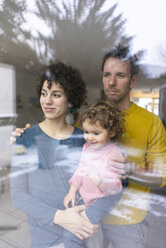 Happy family looking out of window, mother carrying daughter - JOSF03105