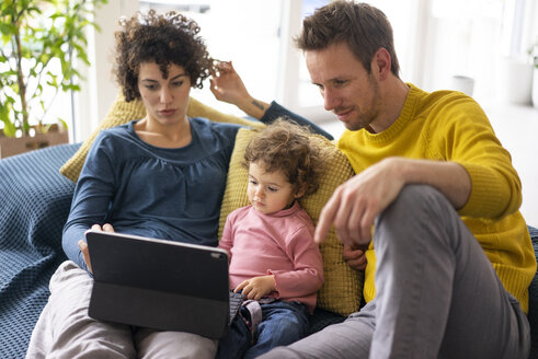 Familie liegt auf der Couch und schaut einen Film auf ihrem Tablet - JOSF03109