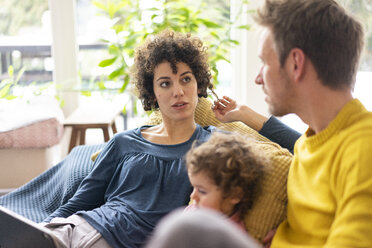 Family lying on couch watching movie on theit tablet - JOSF03110