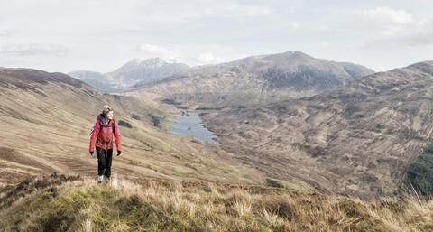 UK, Schottland, Onich, Beinn Na Gucaig, Frau wandert in Berglandschaft, lizenzfreies Stockfoto