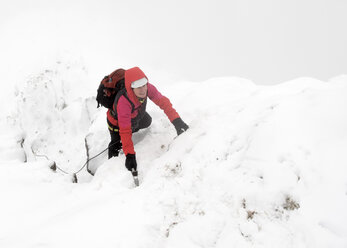 UK, Schottland, Glen Spean, Frau klettert auf den Ostgrat des Beinn a Caorainn im Winter - ALRF01420