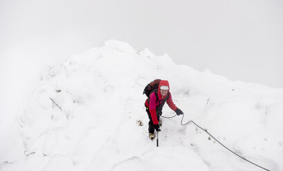 UK, Schottland, Glen Spean, Frau klettert auf den Ostgrat des Beinn a Caorainn im Winter - ALRF01421