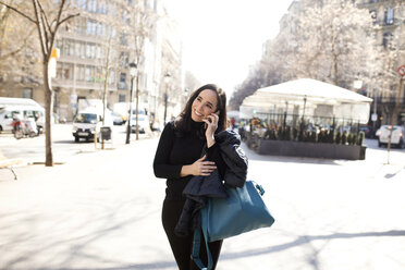 Elegante Frau, die in der Stadt mit einem Handy telefoniert - VABF02226