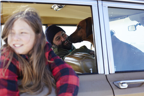 Happy daughter with father and dog in car stock photo