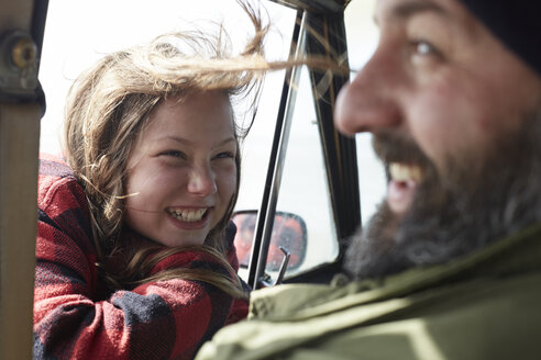 Happy daughter looking at father in car - AMEF00031