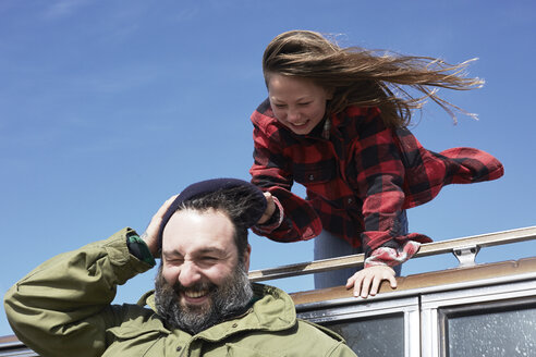Playful daughter pulling cap from father's head - AMEF00037