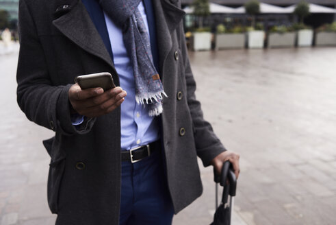 Hand eines Geschäftsmannes mit Mobiltelefon - IGGF00919