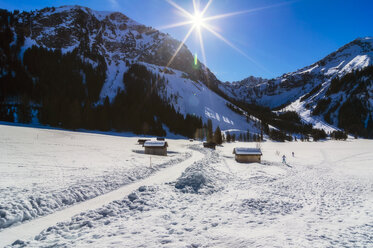 Österreich, Tirol, Tannheimer Tal, Ställe im Winter gegen die Sonne - THAF02483