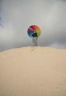 Frau mit buntem Regenschirm auf einer Düne stehend - KBF00548