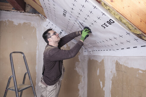 Roof insulation, worker fixing sarking membrane - SEBF00038