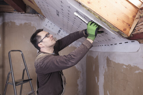 Roof insulation, worker fixing sarking membrane - SEBF00039