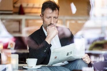 Porträt eines nachdenklichen reifen Geschäftsmannes, der in einem Café Zeitung liest - DIGF06001