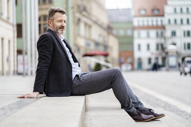 Deutschland, Zwickau, entspannter reifer Geschäftsmann auf Stufen sitzend im Freien - DIGF06007