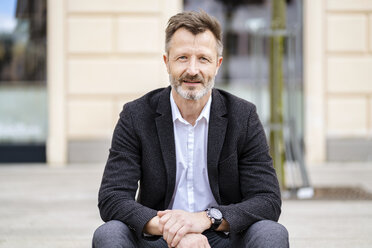 Portrait of smiling mature businessman with greying beard outdoors - DIGF06010