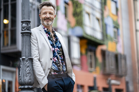 Portrait of fashionable mature man with greying beard leaning against stock photo