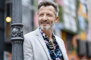 Portrait of fashionable mature man with greying beard leaning against - DIGF06048