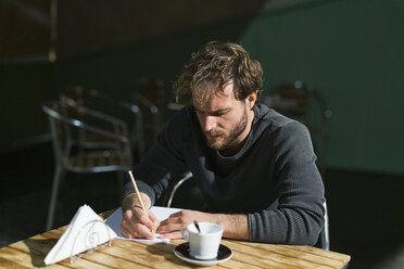 Pensive man sitting in theatre working on script - FBAF00252