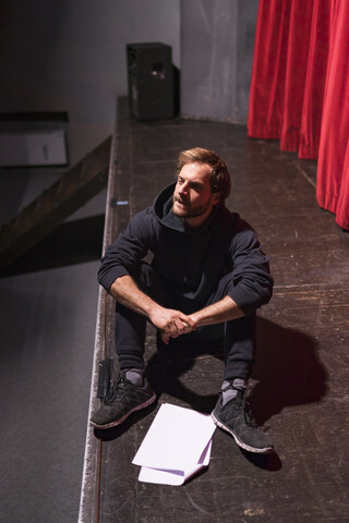 Probender Schauspieler auf der Theaterbühne mit Drehbuch, lizenzfreies Stockfoto