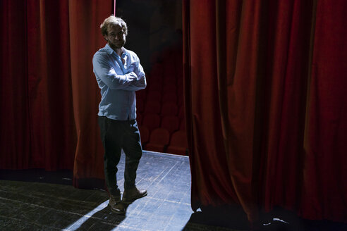 Portrait of man standing on theatre stage - FBAF00308